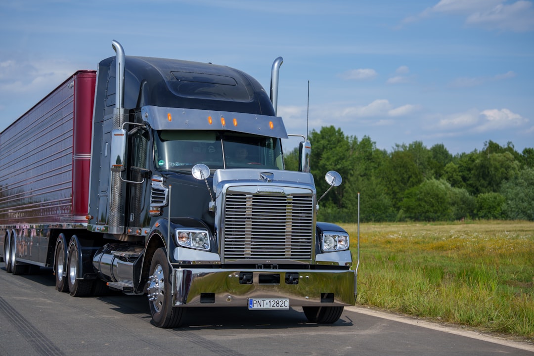 Semi truck with a red trailer on a rural highway
