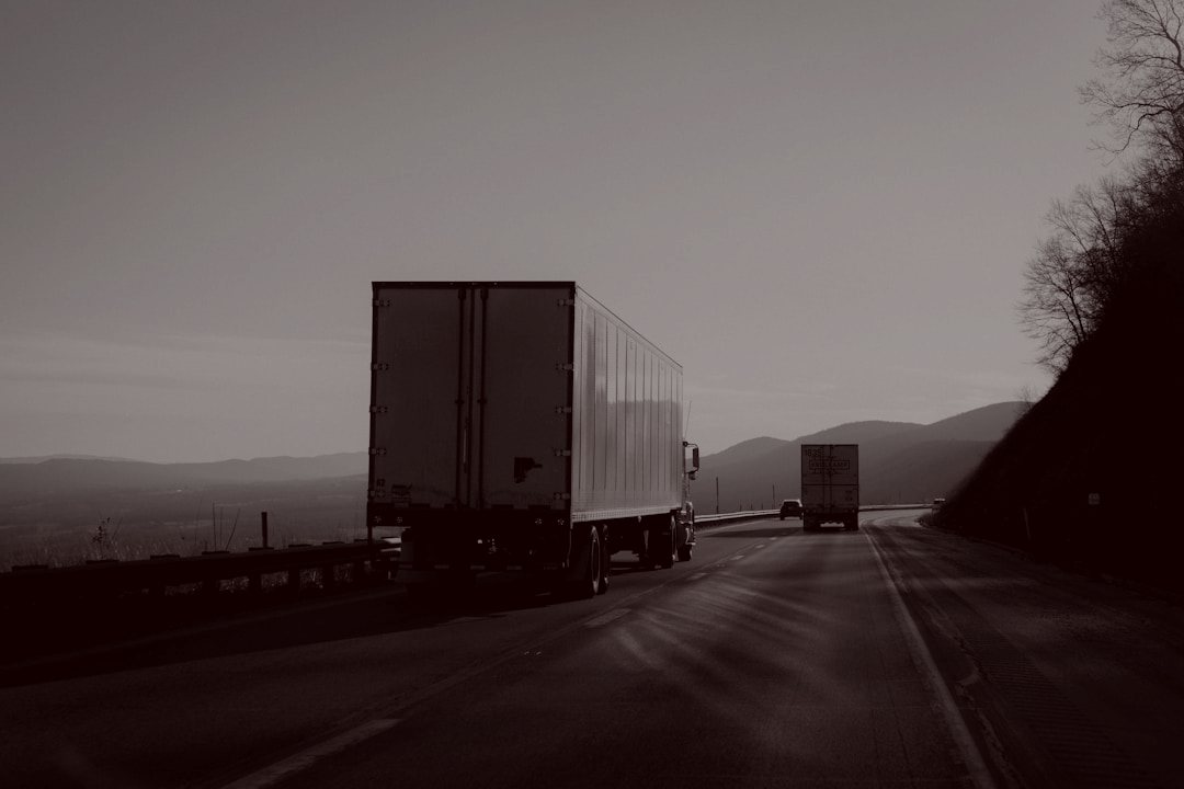 Freight trucks driving on a highway through the mountains at dusk